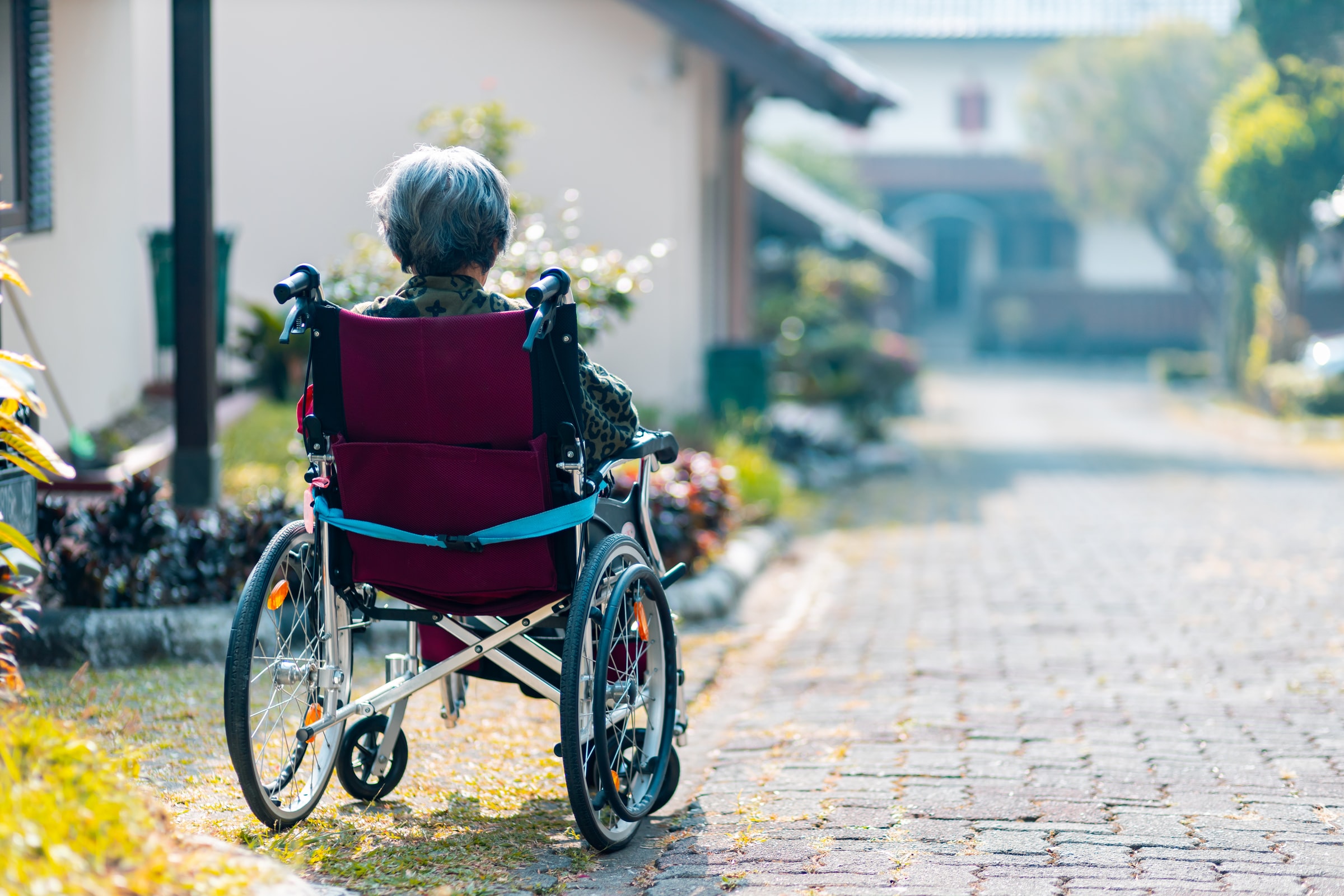 Alte Frau sitzt in Rollstuhl